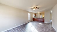 Located at 5265 Canyon Cir in Newburgh, Indiana, this single-story, 2-bedroom, 1-bathroom home offers a practical and efficient layout with clean, modern finishes throughout. The open-concept living and kitchen area serves as the heart of the home, featuring light gray wood-look flooring, neutral beige walls, and a ceiling fan with integrated lighting. Natural light filters in through a double-hung window, brightening the generous living space. The kitchen is defined by warm wood cabinetry, a white countertop peninsula that doubles as a breakfast bar, stainless steel appliances including a refrigerator, microwave, and range, and a sink with a window view — making it both functional and inviting. The two bedrooms continue the consistent flooring and neutral color palette, each benefiting from natural light through large windows that offer views of the surrounding landscape. The full bathroom is equipped with a shower-tub combo, white vanity with storage, and wood-toned cabinetry. The attached garage provides convenient enclosed parking with an automatic opener. This home presents a cohesive, move-in-ready aesthetic with durable finishes suited for comfortable everyday living.