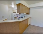 This 600 square foot apartment in South Bend, IN, offers a well-designed living space on a single floor. The layout maximizes functionality with an open-plan design that seamlessly integrates the living area and kitchen. The kitchen is a standout feature, boasting ample wooden cabinetry, a practical breakfast bar, and essential appliances including a refrigerator and gas stove.

The bedroom, measuring 150 square feet, provides a comfortable retreat with a large closet and window for natural light. The bathroom is efficiently designed with a combined tub and shower, a vanity with storage, and modern fixtures. Throughout the apartment, you'll find a mix of flooring materials, including wood-look laminate in the kitchen and bathroom, and carpeting in the bedroom and living areas.

Vaulted ceilings in the main living area create a sense of spaciousness, while windows in various rooms allow for plenty of natural light. The neutral color palette of white walls and light wood tones provides a blank canvas for personalization. This apartment is an ideal choice for those seeking a low-maintenance, cozy living space with modern amenities and efficient design.