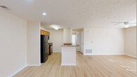 This well-designed single-story home offers 1110 square feet of living space, including three bedrooms and two bathrooms. The property, located at 5311 Poynter Pass Dr in Bargersville, IN, features a modern and functional layout.

The kitchen is a standout feature, boasting granite countertops, wooden cabinetry, and black appliances including a built-in microwave. The open concept design seamlessly connects the kitchen to the living area, creating an ideal space for entertaining.

The primary bedroom, measuring 150 square feet, provides ample space and includes a closet with sliding doors. The other bedrooms also feature carpeting and built-in closets, offering comfortable living spaces.

The bathrooms are well-appointed, with one featuring a shower/tub combination with curved shower rod and built-in shelving. Throughout the home, you'll find a neutral color palette with cream walls and white trim, complemented by a mix of light hardwood and carpet flooring.

Large windows in several rooms allow for plenty of natural light, enhancing the bright and airy feel of the space. The home's layout is efficient, with a good flow between rooms and no wasted space. This property offers a comfortable and modern living environment in a desirable location.