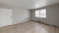 Located at 125 Roxboro Circle in Syracuse, NY, this two-bedroom, two-bathroom unit offers a practical and efficiently designed single-floor layout. The living area features light wood-look luxury vinyl flooring, neutral gray walls, and windows that bring in natural light, along with a wall-mounted air conditioning unit and baseboard heating for year-round comfort.

The kitchen is thoughtfully appointed with white cabinetry, bold dark stone-patterned countertops, black hardware accents, and stainless steel appliances. A window above the counter allows natural light to brighten the workspace.

Both bedrooms are carpeted in a warm neutral tone, providing a comfortable feel underfoot. The primary bedroom offers a generous footprint with windows overlooking the exterior and a baseboard heater. The second bedroom features a built-in closet with bi-fold doors, neutral carpeting, and its own window. A connecting room adds flexible living space between the two bedrooms.

The bathrooms include a full tub-and-shower combination with white tile surround and chrome fixtures, complemented by wood-look flooring. A hallway connects all rooms, lending a cohesive flow throughout the unit. Clean finishes and a neutral palette make this a move-in-ready space.