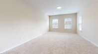 This single-floor residence in Bay Shore, NY offers a well-organized, open layout designed for comfortable everyday living. The kitchen serves as a central feature of the unit, equipped with stainless steel appliances including a gas range, refrigerator, and range hood. Warm-toned wood cabinetry provides ample storage, while dark countertops and a stainless steel sink add a clean, functional aesthetic. A peninsula extends from the kitchen, creating a natural division between the cooking area and the adjacent living space, which transitions from hardwood-style flooring to plush wall-to-wall carpeting.

The living area is generously proportioned, with neutral walls and recessed lighting lending a bright, airy feel. A hallway connects the main living space to the bedroom areas, with a closet providing additional storage. The carpeted bedrooms are spacious and well-lit, each featuring windows dressed with blinds that allow natural light while maintaining privacy, with views of surrounding trees.

The bathroom is cleanly appointed with marble-style tile flooring, a vanity with a light countertop, and a walk-in shower enclosed by sliding glass doors with chrome accents. Overall, the space presents a consistent, neutral palette throughout, creating a cohesive and move-in ready environment.
