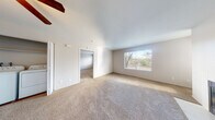 This single-floor residence offers a thoughtfully designed layout that balances comfort and functionality throughout. The living room serves as the heart of the home, featuring a classic fireplace framed by clean white surroundings, plush wall-to-wall carpeting, and a large window that floods the space with natural light and frames views of the surrounding greenery. A ceiling fan adds to the room's practicality. The kitchen is well-equipped with rich dark wood cabinetry, light-toned countertops, and black appliances including a refrigerator, electric range, and built-in microwave. Wood-look flooring adds warmth and is easy to maintain. The bedrooms are generously sized, each carpeted for comfort and outfitted with windows that bring in natural light. Closet space is readily available, with at least one bedroom featuring a dedicated closet. The bathroom continues the cohesive design with matching dark wood vanity cabinetry, a light countertop, wood-look flooring, and a window for natural ventilation. A convenient in-unit laundry area with a full-size washer and dryer adds everyday practicality. The neutral color palette throughout creates a bright, welcoming atmosphere well-suited to a variety of furnishing styles.