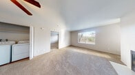 This single-floor residence offers a thoughtfully designed layout that balances comfort and functionality throughout. The living room serves as the heart of the home, featuring a classic fireplace framed by clean white surroundings, plush wall-to-wall carpeting, and a large window that floods the space with natural light and frames views of the surrounding greenery. A ceiling fan adds to the room's practicality. The kitchen is well-equipped with rich dark wood cabinetry, light-toned countertops, and black appliances including a refrigerator, electric range, and built-in microwave. Wood-look flooring adds warmth and is easy to maintain. The bedrooms are generously sized, each carpeted for comfort and outfitted with windows that bring in natural light. Closet space is readily available, with at least one bedroom featuring a dedicated closet. The bathroom continues the cohesive design with matching dark wood vanity cabinetry, a light countertop, wood-look flooring, and a window for natural ventilation. A convenient in-unit laundry area with a full-size washer and dryer adds everyday practicality. The neutral color palette throughout creates a bright, welcoming atmosphere well-suited to a variety of furnishing styles.