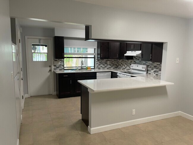 Cocina reformada con barra. - 2051 Cove Ln