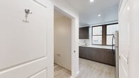 Located at 201 Cornelison Avenue in Jersey City, NJ, this one-bedroom, one-bathroom unit offers a thoughtfully designed layout across a single floor. Light wood-tone flooring flows throughout, lending a clean and cohesive aesthetic to the entire space.

The kitchen is a standout feature, outfitted with dark espresso cabinetry, white quartz countertops, a subway tile backsplash, and a full suite of stainless steel appliances including a range, over-the-range microwave, and refrigerator. A window above the sink provides natural light, enhancing the modern, functional design.

The kitchen opens directly into the living room, creating an open, connected feel. The living area is bright and airy, with a large window that invites additional natural light. The bedroom is a comfortable, well-proportioned room featuring two windows and light wood flooring, offering a calm and restful environment.

The bathroom is finished with large-format tile flooring, a tub/shower combo with subway tile surround, a modern vanity with a mirrored medicine cabinet, and brushed gold fixtures. Additional highlights include two closets for ample storage, a dedicated utility room, and in-unit laundry — a rare and practical amenity. Recessed lighting throughout adds to the clean, contemporary feel of the unit.
