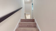 This three-floor home offers a thoughtfully designed layout across its levels, providing functional living spaces throughout. The kitchen is a standout area, featuring dark cabinetry with raised-panel detailing, granite-look countertops, stainless steel appliances including a refrigerator, range, microwave, and dishwasher, and durable wood-look flooring. A sliding glass door in the kitchen provides convenient access to the outdoors.

The upper level bedrooms are carpeted and bright, with vaulted ceilings adding a sense of height and openness. One bedroom is particularly notable for its striking arched window above two large standard windows, flooding the room with natural light and offering pleasant exterior views. Soft neutral tones carry throughout, creating a calm and cohesive atmosphere.

The bathrooms are finished with dark-toned vanity cabinetry, white countertops, and wood-look flooring. One bathroom includes a soaking tub with decorative tile trim, while another offers a tub-shower combo.

Carpeted staircases with a metal handrail connect the floors smoothly. The attached garage provides ample vehicle storage, while the unfinished basement level houses the mechanical systems and a utility sink, offering potential for future use or additional storage.