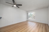 Located at 860 W Fifth St in the San Pedro neighborhood of Los Angeles, this one-bedroom, one-bathroom unit offers a well-organized, efficient layout spread across a single floor. Light wood laminate flooring runs throughout the space, complementing the crisp white walls and textured ceilings to create a clean, modern aesthetic.

The combined kitchen and living area forms the heart of the unit. The kitchen features white cabinetry, granite-style countertops, stainless steel appliances including a refrigerator, and a built-in sink — all arranged along a peninsula that opens to the living area. A ceiling fan overhead aids ventilation, while a window at the far end of the living space draws in natural light and offers views of surrounding greenery.

The bedroom is a comfortably sized private retreat with light wood flooring, white walls, and a ceiling fan. A large sliding window frames an outdoor view of lush vegetation, allowing abundant natural light to fill the room. A dedicated closet provides practical storage.

The bathroom is clean and functional, finished in white with wood flooring, and includes a full bathtub with an overhead shower, toilet, and vanity. The overall design of the unit prioritizes simplicity and light, making it a practical and comfortable home in the Los Angeles coastal area.