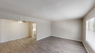 Located at 5930 Red Bluff Rd in Pasadena, TX, this single-story, 3-bedroom, 2-bathroom home offers a practical and comfortable layout across a well-utilized floor plan. The interior features two separate living areas, both equipped with ceiling fans and light-toned wood-look vinyl flooring that lend a clean, modern feel throughout the common spaces. Natural light filters in through blinded windows, brightening the neutral-toned walls and textured ceilings. The kitchen includes gray cabinetry and marble-look countertops, providing functional workspace. A dedicated laundry area with built-in shelving and utility hookups adds everyday convenience. The three bedrooms are carpeted for comfort, with the spacious primary bedroom featuring a walk-in closet and a ceiling fan, along with a window that brings in natural light. The two additional bedrooms are cozy and well-lit, each with windows and neutral finishes. The two bathrooms differ in style: one features clean white subway tile surrounding a tub/shower combo, while the second offers warm earth-toned tile accents alongside a soaking tub and wood-look flooring. A connecting hallway ties the layout together, making this home functional and move-in ready.