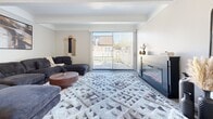 This multi-floor home in Columbus, OH (43209) offers a thoughtfully organized layout spread across three levels. The entry level provides a compact but functional foyer that transitions into the main living areas above. The primary living floor features an open-plan arrangement where a carpeted living room anchors the space, complete with a sleek fireplace and a large sliding glass door that fills the room with natural light. Adjacent to the living room, the dining area accommodates a full-sized table and is framed by a tray ceiling with accent lighting. The kitchen is efficiently designed with dark cabinetry, white countertops, stainless steel appliances including a refrigerator and dishwasher, and light hardwood-style flooring. A dedicated utility area and hallway connect the main spaces with ease. The upper floor hosts two bedrooms, including a generously sized primary bedroom with plush carpeting, a walk-in closet, and ample room for a full furniture arrangement. Two full bathrooms serve the home, each finished with clean white vanities and tiled tub-shower combinations. A staircase with carpet treads links all three floors, and additional storage is provided through a dedicated closet.