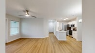 This single-story, 2-bedroom, 2-bathroom home in Jacksonville, FL (32218) offers a clean, modern aesthetic throughout. Light-toned hardwood-style flooring runs through the main living areas, while plush carpet adds comfort to both bedrooms. The open kitchen is a standout feature, equipped with white shaker cabinetry, white quartz countertops, a subway tile backsplash, stainless steel appliances including a refrigerator, microwave, and range, and a peninsula with an undermount sink — ideal for both cooking and casual dining. The living area flows naturally from the kitchen and is brightened by recessed lighting and a ceiling fan. Both bedrooms are generously sized, each featuring a ceiling fan and walk-in closet outfitted with wire shelving systems. The primary bedroom includes French doors that open to outdoor views, while the second bedroom features a large window with natural greenery views. The two bathrooms are finished with white vanities and marble-style tile surrounds in the tub/shower. A dedicated laundry room with wire shelving and washer/dryer hookups adds everyday convenience. The home presents a bright, neutral palette throughout, creating a clean and functional living environment.