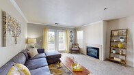 Located in Castle Rock, Colorado, this single-floor 2-bedroom, 2-bathroom residence offers a thoughtfully designed layout that balances comfort and functionality. The living room serves as the heart of the home, featuring crown molding, plush carpet, a tile-surround fireplace, and large glass doors that flood the space with natural light and provide access to an outdoor balcony. Adjacent to the living area, the dedicated dining room offers an intimate setting with crown molding and a pendant light fixture overhead. The galley-style kitchen is equipped with white cabinetry accented with wood trim, laminate countertops, and durable wood-look flooring, with a pass-through connection to the laundry area. A carpeted hallway lined with closet storage connects the main living spaces to the bedrooms. The spacious primary bedroom is bright and airy, benefiting from large windows with vertical blinds that allow generous natural light. The second bedroom mirrors this comfort with its own ample proportions and natural light. Both bathrooms are clean and functional, with one featuring a full tub-shower combination. The home is completed by two laundry areas and additional closet space throughout.