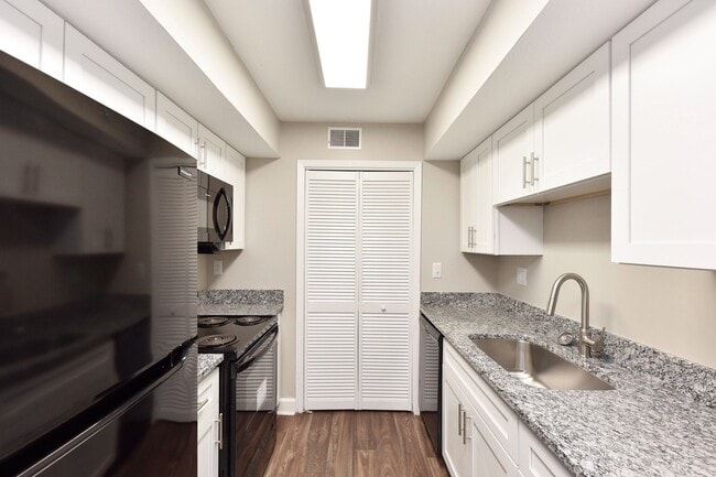 Kitchen with granite counters, black appliances, and modern cabinetry - Harpeth Trace