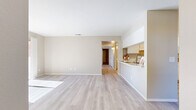 Located at 43230 Gadsden Ave in Lancaster, CA, this single-story, 4-bedroom, 2-bathroom home offers a well-organized and functional layout. The open-concept living and dining area is finished with light wood-style flooring and neutral warm beige walls, creating a bright and welcoming atmosphere. Sliding glass doors flood the living space with natural light and provide access to an outdoor patio with tree-lined views. The kitchen features white cabinetry, a stainless steel sink, light stone countertops, a breakfast bar peninsula, and white appliances including a range and refrigerator — offering both practicality and a clean aesthetic. A hallway connects the main living areas to the four bedrooms, each carpeted for comfort. The primary bedroom is generously sized and includes dedicated closet space. Additional bedrooms are well-proportioned, each with natural light from windows and sliding closet doors. With a total of six closets throughout the home, storage is plentiful. The two bathrooms are finished in neutral tones, with one featuring a glass-enclosed walk-in shower. Ceiling fans in the bedrooms add to the home's comfort. The layout flows efficiently, making this a practical and comfortable single-floor residence.