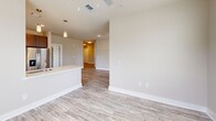 Located at 11215 Royal Creek Dr in Fuquay-Varina, NC, this single-floor, 2-bedroom, 3-bathroom home offers a thoughtfully designed layout with modern finishes throughout. The open-concept living and kitchen area is anchored by light wood-look flooring, neutral walls, and abundant natural light from multiple windows. The kitchen is a standout feature, boasting rich dark cabinetry, subway tile backsplash, stainless steel appliances, a central island with a sink, pendant lighting, and generous counter space — ideal for both everyday cooking and entertaining. The living area flows seamlessly from the kitchen and is fitted with a ceiling fan overhead. The primary bedroom is a comfortable retreat with plush carpet, a ceiling fan, and a window with outdoor views, complemented by a spacious walk-in closet with full wire shelving systems. The en-suite bathroom features a dual-sink vanity with dark cabinetry, a large mirror, and wood-look flooring. Additional bathrooms include a tub-shower combo adorned with classic white subway tile and brushed nickel fixtures. A dedicated laundry room accommodates a full-size washer and dryer with overhead wire shelving for storage. The second bedroom is equally well-appointed with soft carpet and natural light.