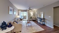 Located at 550 Mount Zion Rd in Florence, Kentucky, this well-appointed 2-bedroom, 2-bathroom single-floor residence offers a thoughtfully designed layout across a comfortable footprint. The living room serves as the heart of the home, featuring wood-style flooring, a ceiling fan, and a sliding glass door that floods the space with natural light and opens onto a private balcony. Adjacent to the living room, the dining area is accented by a stylish round chandelier and chair-rail molding, creating an inviting space for meals and gatherings. The galley-style kitchen is outfitted with warm wood cabinetry, white countertops, stainless steel appliances, and wood-style flooring, offering ample storage and counter space. Both bedrooms are carpeted for comfort; the primary bedroom is generously sized and includes a walk-in closet, while each room benefits from natural light via well-positioned windows. The two bathrooms feature warm wood vanities, white countertops, and wood-style flooring, with one showcasing a lighted vanity mirror and extended countertop. A dedicated in-unit laundry room with a full-size washer and dryer adds everyday convenience. Neutral gray tones throughout create a calm, cohesive ambiance across the entire residence.