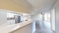 This single-floor, 3-bedroom, 2-bathroom unit offers a practical and comfortable layout designed for everyday living. The open-concept living and kitchen area serves as the heart of the home, where a peninsula with light quartz countertops and an undermount sink separates the kitchen from the living space. The kitchen is equipped with stainless steel appliances, including a refrigerator and electric range, complemented by a neutral subway tile backsplash and white cabinetry. Wood-look flooring flows throughout the main living areas, adding warmth and continuity.

The living room is bright and airy, featuring a ceiling fan and large sliding glass doors that open onto a private balcony with views of lush greenery. The textured ceilings are consistent throughout the unit, adding a classic residential character.

The three bedrooms are carpeted for comfort, each offering ceiling fans and natural light through sliding or standard windows. The primary bedroom provides a generous amount of space, with a closet and outdoor views.

Both bathrooms are finished with white vanities, quartz countertops, and tub-shower combinations with clean tile surrounds. A dedicated laundry area with an in-unit washer and dryer adds significant convenience. The hallway connects all rooms efficiently, completing this functional and well-designed layout.