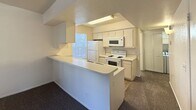 This efficient 430-square-foot, single-floor unit at 800 W Forest Meadows Street in Flagstaff, Arizona offers a practical and well-organized layout designed to maximize every square foot. The space includes one bedroom and one kitchen, making it an ideal option for a single occupant or couple seeking a manageable living space in the Flagstaff area.

The kitchen is a standout feature of this unit, designed in a galley style with white cabinetry lining both sides, offering ample storage and counter space. It is fully equipped with white appliances including a coil-burner electric range, over-the-range microwave, refrigerator, and dishwasher. A window above the sink brings in natural light, and tile flooring adds durability to this functional workspace. A breakfast bar peninsula separates the kitchen from the living area, providing additional counter space and a casual dining option.

The bedroom spans 130 square feet and features neutral, textured white walls and wall-to-wall carpet, creating a quiet and comfortable retreat. The room offers a clean, open canvas well-suited to a variety of furniture arrangements. The overall aesthetic of the unit is clean and neutral, with white walls and light-toned finishes throughout, lending a bright and tidy character to the space.