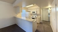 This efficient 430-square-foot, single-floor unit at 800 W Forest Meadows Street in Flagstaff, Arizona offers a practical and well-organized layout designed to maximize every square foot. The space includes one bedroom and one kitchen, making it an ideal option for a single occupant or couple seeking a manageable living space in the Flagstaff area.

The kitchen is a standout feature of this unit, designed in a galley style with white cabinetry lining both sides, offering ample storage and counter space. It is fully equipped with white appliances including a coil-burner electric range, over-the-range microwave, refrigerator, and dishwasher. A window above the sink brings in natural light, and tile flooring adds durability to this functional workspace. A breakfast bar peninsula separates the kitchen from the living area, providing additional counter space and a casual dining option.

The bedroom spans 130 square feet and features neutral, textured white walls and wall-to-wall carpet, creating a quiet and comfortable retreat. The room offers a clean, open canvas well-suited to a variety of furniture arrangements. The overall aesthetic of the unit is clean and neutral, with white walls and light-toned finishes throughout, lending a bright and tidy character to the space.