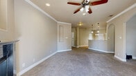 Located at 5455 Rowley Rd in San Antonio, TX, this well-designed single-story home offers three bedrooms, two bathrooms, and a thoughtfully organized floor plan. The open-concept living area features plush carpeting, crown molding, recessed lighting, and a ceiling fan with light fixture, creating a bright and comfortable gathering space that flows naturally into the kitchen. The kitchen is outfitted with warm wood cabinetry, granite-look countertops, stainless steel appliances, a built-in dishwasher, and elegant pendant lighting that illuminates the counter workspace. The bedrooms are carpeted and feature ceiling fans, arched windows that allow natural light to filter through, and a calm, neutral color palette. The primary bedroom offers a generous footprint with ample space for furnishings. The two bathrooms are finished with tile flooring and rich wood vanities with white countertops; one includes a curved glass-enclosed shower stall with mosaic tile accents, while the other features grab bars for added accessibility. Additional highlights include a hallway, two closets, a dedicated laundry room, a utility room, and two balconies overlooking the surrounding neighborhood with mature trees and open sky views.