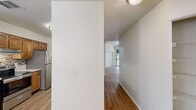 This well-appointed single-story residence spans 970 square feet and offers 1 bedroom, 3 bathrooms, and 2 closets. Warm wood-look flooring runs consistently throughout, lending a cohesive aesthetic to the entire unit. The living room serves as a central gathering space, anchored by a stone-surround fireplace and fitted with a ceiling fan. Sliding glass doors open onto a balcony, bringing in natural light and outdoor greenery views, while an adjacent window further brightens the space. The combined kitchen and living area features warm-toned wood cabinetry, light countertops with a tile backsplash, stainless steel appliances including a refrigerator, range, and dishwasher, and a corner sink with a window overlooking the balcony. A dedicated laundry closet with shelving is conveniently accessible from the kitchen. The primary bedroom measures 140 square feet, includes a ceiling fan, and connects to a walk-in closet with built-in shelving. The bathrooms are clean and functional, with one featuring a full soaking tub and shower combination. Textured ceilings are present in select rooms, adding architectural character. Ceiling fans with integrated lighting fixtures are installed throughout, ensuring comfort and practicality across the home.