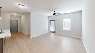 Located at 4582 Ruby Red Dr in Chattanooga, TN, this one-bedroom, one-bathroom apartment delivers a thoughtfully designed single-floor layout with modern finishes throughout. The open-concept kitchen and living area serves as the heart of the unit, featuring light wood-look flooring, a ceiling fan, and a window with blinds that invites natural light into the space. The kitchen is well-appointed with rich dark wood cabinetry, a white subway tile backsplash, stainless steel appliances — including a refrigerator, range, and microwave — and a standout kitchen island with a marble-look countertop and built-in sink, accented by stylish pendant lighting overhead. The bedroom offers plush carpeting, a ceiling fan, a window for natural light, and a closet with built-in shelving for convenient storage. The bathroom includes a vanity with a marble-look countertop, dark wood cabinetry, a large mirror, and a full soaking tub with a shower combo. A dedicated laundry room with a full-size washer and dryer completes the unit, adding everyday practicality. Clean gray walls and consistent trim work throughout give the space a cohesive, modern aesthetic.