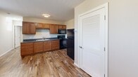 This well-appointed one-bedroom, one-bathroom unit at 1125 S Walnut St in Muncie, Indiana offers a practical and comfortable layout across a single floor. Warm-toned hardwood-style flooring runs throughout, lending a cohesive and inviting feel to the entire space.

The kitchen is a standout feature, equipped with rich medium-toned wood cabinetry extending to the upper walls for generous storage. Dark granite-style countertops provide ample prep surface, and the kitchen includes a double-basin stainless steel sink, a black electric range, a built-in microwave, and a full-size refrigerator. A louvered closet door adjacent to the kitchen offers additional storage convenience.

The bedroom is a calm, neutral space with cream-colored walls and natural light from a window. Arched panel doors and a dedicated closet add both style and functionality to the room.

The bathroom features the same hardwood-style flooring as the rest of the unit, warm beige walls, a wood-toned vanity with a white countertop, and a full tub and shower enclosure with chrome fixtures. The clean, bright design creates a relaxing atmosphere.

This unit is an excellent choice for those seeking a compact, efficiently designed living space in Muncie, Indiana.