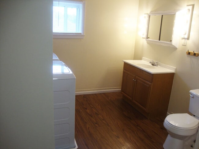 Bathroom vanity and stool on right. Laundry area on left. - 325 Mercer St