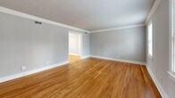 Located at 41½ Malvern Ave in Richmond, Virginia's desirable 23221 zip code, this well-appointed 2-bedroom, 1-bathroom single-floor home offers a thoughtfully designed layout across a comfortable footprint. Warm hardwood floors run throughout the main living areas and bedrooms, complemented by soft grey walls and crisp white trim that create a clean, cohesive aesthetic.

The galley-style kitchen is a standout feature, showcasing white shaker cabinetry with brushed nickel hardware, sparkling quartz countertops with subtle veining, a classic subway tile backsplash, and a full suite of stainless steel appliances including a gas range, built-in microwave, dishwasher, and refrigerator. The kitchen opens conveniently toward the dining area, facilitating easy everyday living.

The living room and dining room offer open, airy spaces accentuated by crown molding details. Both bedrooms are generously proportioned, filled with natural light from multiple windows, and feature ample closet space — with five closets distributed throughout the home. The primary bedroom is notably spacious.

The bathroom features a quartz-topped vanity with an undermount sink and tile flooring, maintaining the modern finishes found throughout. Additional conveniences include an in-unit laundry area and a connecting hallway that ties the layout together seamlessly.