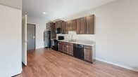 Located at 520 Payne Ave in Saint Paul, Minnesota, this one-bedroom, one-bathroom unit offers a thoughtfully designed layout across a single floor. The kitchen is a standout feature, showcasing rich dark-stained cabinetry with sleek hardware, granite countertops, wood-style flooring, and a full suite of black appliances including a refrigerator, electric range, built-in microwave, and dishwasher — providing both style and functionality in a compact, efficient space. The open sightlines from the kitchen create a cohesive flow throughout the unit. The bedroom is a comfortable, carpeted retreat featuring a ceiling fan, a natural light-filled window with blinds, and a sliding-door closet equipped with wire shelving and hanging rods for ample storage. The bathroom continues the upscale aesthetic with wood-style flooring, dark wood cabinetry, a granite-topped vanity, a large mirror, and a tub/shower combination. Neutral wall tones throughout the unit create a clean, versatile backdrop. The overall ambiance is modern and move-in ready, offering a practical yet polished living environment in the heart of Saint Paul.