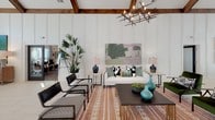 Located at 7001 Wiley Dr in Simpsonville, SC, this single-floor community clubhouse delivers an impressive blend of modern farmhouse design and upscale amenity space. The interior is anchored by soaring vaulted ceilings adorned with richly stained exposed wood beams, creating a dramatic architectural backdrop throughout. Crisp white board-and-batten wall paneling lends a clean, contemporary contrast to the warm, natural wood overhead.

The main lounge area is generously proportioned and bathed in natural light, thanks to an expansive wall of floor-to-ceiling windows and French doors that frame views of the surrounding community. Comfortable seating arrangements, curated artwork, and eclectic furnishings give the space a welcoming, residential feel. A shuffleboard table adds a recreational touch to the lounge.

A dedicated game room features a full-size billiards table set against light tile flooring, with a connecting hallway leading to additional areas of the facility.

The bar and café area showcases a dramatic teal patinated tile feature wall, dual wall-mounted televisions, a dark granite countertop with bar seating, pendant lighting with gold-interior shades, and a built-in coffee and beverage station — ideal for casual gatherings. Throughout the space, thoughtfully selected art, layered rugs, and lush greenery complete the polished yet approachable atmosphere.