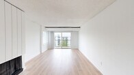 Located at 180 S Van Dorn St in Alexandria, Virginia, this two-bedroom, one-bathroom residence offers a clean, modern aesthetic throughout its single-floor layout. Light wood luxury vinyl flooring flows continuously throughout the home, complementing the crisp white walls and textured ceilings that create a bright, airy atmosphere.

The open-concept living and kitchen area serves as the heart of the home. The kitchen is outfitted with white shaker-style cabinetry, white quartz countertops, a stainless steel sink, and stainless steel appliances including a gas range, microwave, and refrigerator, along with a subway tile backsplash. The spacious living area receives abundant natural light through large windows with blinds and a sliding glass door that opens to a private balcony with outdoor views of surrounding greenery.

A fireplace feature wall adds a distinctive architectural detail to the living space. The hallway connects the two bedrooms, each offering generous proportions and natural light. The primary bedroom is notably spacious and includes a large sliding-door closet. The full bathroom features a white tiled tub and shower combination. Additional highlights include in-unit laundry, three closets for ample storage, and a well-connected location in Alexandria.