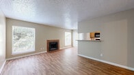 Located at 11800 Pleasant Ridge Rd in Little Rock, Arkansas, this single-floor, 3-bedroom, 3-bathroom home offers a functional and comfortable layout. The open living area serves as the heart of the home, featuring warm wood-look flooring, a textured ceiling, and a tile-surround fireplace that adds character and coziness. Multiple windows allow natural light to fill the space, while a sliding glass door with vertical blinds provides outdoor access. The kitchen is designed in a galley style, lined with warm oak cabinetry, laminate countertops, and black appliances including a range, microwave, dishwasher, and refrigerator — maximizing efficiency within the space. A pass-through counter connects the kitchen to the living and dining area. Each of the three bedrooms is carpeted and includes a ceiling fan with light fixture, offering comfort and practicality. The primary bedroom features its own dedicated closet with built-in shelving rods. The bathrooms are straightforward in design, each featuring wood-look flooring and a tub-shower combination. A hallway connects the private quarters and includes additional closet storage. The overall palette of neutral beige tones throughout creates a clean, cohesive ambiance well-suited for everyday living.