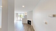 Located on Federal Avenue in the desirable West Los Angeles neighborhood of 90025, this thoughtfully designed studio offers a clean, modern aesthetic with an efficient single-floor layout. Light-toned hardwood-style flooring runs throughout the space, creating a cohesive and airy feel.

The open living area is bright and welcoming, bathed in natural light that pours in through a floor-to-ceiling sliding glass door. This door leads directly to a private balcony framed by lush, mature trees — offering a serene, green outlook that brings a touch of nature into the urban setting. Recessed lighting complements the natural light, and a fireplace adds a charming architectural focal point to the room. A half-wall partition suggests a defined kitchen area nearby.

The bathroom is well-appointed with a white vanity featuring brushed nickel hardware, a quartz countertop, a large dark-framed mirror, and a combination shower/tub — all finished with the same light hardwood-style flooring that ties the space together.

A dedicated closet provides practical storage. The overall palette of crisp white walls and neutral flooring lends the space a fresh, move-in-ready quality, making it an inviting and functional residence in a prime Los Angeles location.
