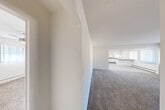 Located at 1099 Maiden Ln in Ann Arbor, Michigan, this single-floor, three-bedroom, one-bathroom home offers a practical and well-organized layout. The entrance opens into a hallway that connects the main living areas, providing a smooth flow throughout the space. The open living room is generously sized, featuring neutral-toned carpet and crisp white walls that create a bright, clean atmosphere. The combined kitchen and dining area is a functional highlight, featuring white cabinetry with modern hardware, dark granite-style countertops, a peninsula breakfast bar, recessed lighting, and white appliances including a gas range and refrigerator — all set on light wood-style flooring. The three bedrooms are carpeted and well-lit, each equipped with ceiling fans and ample closet space — four closets total are distributed throughout the home. The primary bedroom offers a comfortable footprint with natural light filtering through window treatments. The full bathroom is cleanly appointed with a white vanity, tub/shower combination, and hard-surface flooring. Baseboard heating is present throughout, and the living room features a wall AC unit. The home's neutral palette and straightforward design make it a versatile and move-in-ready option.