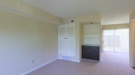 Located at 4695 Braddock Ct in Columbus, Ohio, this two-floor home offers a practical and comfortable layout designed for everyday living. The interior features neutral, light-toned walls that create a bright and airy atmosphere throughout the space. Carpeted flooring runs through the living areas, adding warmth underfoot.

A standout feature of the main living area is the built-in shelving unit, which provides generous display and storage space, accompanied by a dark-cabineted storage console with a stone-topped surface — a stylish and functional combination. Louvered closet doors add a classic touch while offering ample storage capacity. Dual HVAC vents are positioned thoughtfully in the ceiling and lower wall areas, ensuring consistent climate control.

Natural light filters in through a sliding glass door, hinting at outdoor access and lending the space a welcoming brightness. The overall design emphasizes clean lines and efficient use of space, with recessed alcoves and structured storage making the most of every corner. Spanning two floors, this home provides room for distinct living and private sleeping areas, offering a well-organized and versatile floor plan suited to a variety of lifestyles.