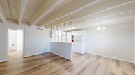 Located at 1033 Madeira Dr SE in Albuquerque, New Mexico, this single-story one-bedroom, one-bathroom home offers a thoughtfully designed layout with a warm Southwestern character. A defining architectural feature throughout the space is the series of exposed ceiling beams, which add texture, depth, and a rustic yet refined charm to every room.

The living area is generously proportioned, bathed in natural light streaming through a sliding glass door that opens to an outdoor space, as well as additional windows that frame views of the surrounding greenery. Warm-toned hardwood-style flooring runs continuously throughout, creating a cohesive and inviting ambiance. A pendant light fixture anchors the room, adding a subtle vintage touch.

The bedroom is a comfortable and well-sized retreat, featuring a large built-in closet with sliding doors, a window with outdoor views, and the same exposed beam ceiling detail found throughout the home. Its layout allows for flexible furniture arrangement.

The bathroom is clean and functional, featuring a white vanity, tile-surround shower, and wood-style flooring that ties into the rest of the home's aesthetic. The consistent use of neutral tones and natural materials throughout the home creates a calm, cohesive atmosphere well-suited to everyday living.