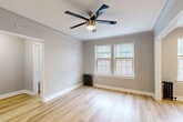 Located at 212 S Oak Park Ave in the vibrant community of Oak Park, Illinois, this thoughtfully designed one-bedroom, one-bathroom unit offers an efficient and well-appointed single-floor layout. Light wood flooring flows throughout the space, lending warmth and visual continuity to every room.

The bedroom is a comfortable and airy retreat, featuring a ceiling fan with integrated lighting, neutral gray walls, clean white trim, and a classic cast-iron radiator beneath a pair of windows fitted with blinds that allow for natural light control. A closet provides dedicated storage.

The kitchen is a standout feature, equipped with stainless steel appliances including a French door refrigerator, gas range, and over-the-range microwave. Two-tone cabinetry — white uppers paired with navy lowers — is complemented by a marble-look countertop and a hexagonal tile backsplash, giving the space a modern yet timeless aesthetic.

The bathroom continues the refined design language with floor-to-ceiling large-format white tile in the tub surround, a navy vanity topped with a marble-look countertop, brushed nickel fixtures, and a window that introduces natural light. Every detail reflects a clean, contemporary sensibility throughout this efficiently utilized Oak Park residence.
