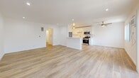 Located in Sherman Oaks, Los Angeles, this 2-bedroom, 2-bathroom single-story home offers a clean, modern aesthetic with thoughtful updates throughout. The open-concept living and kitchen area serves as the heart of the home, featuring light wood-tone flooring, recessed lighting, and ceiling fans that promote comfortable airflow. Sliding glass doors in the living area invite natural light and provide access to an outdoor space.

The kitchen is well-appointed with white shaker cabinetry, stone-look countertops, a decorative tile backsplash, and stainless steel appliances including a gas range, microwave, refrigerator, and dishwasher. A peninsula counter adds functional workspace and separation between the kitchen and living area.

Both bedrooms continue the consistent light wood flooring and crisp white walls, each equipped with ceiling fans and windows that allow natural light. The spacious primary bedroom offers a comfortable, airy feel. The two bathrooms are cleanly finished — one features a white vanity with a stone countertop and modern fixtures, while the other includes a full tub-shower combo with white tile surround and a window for ventilation. A connecting hallway ties all rooms together, creating a practical and cohesive floor plan throughout this well-maintained Los Angeles home.