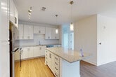 Located at 9091 Baltimore Ave in College Park, MD, this well-appointed 3-bedroom, 2-bathroom single-floor residence offers a thoughtfully designed layout with modern finishes throughout. The open-concept living area seamlessly connects the kitchen, dining, and living spaces, creating a bright and functional common area. The kitchen is a standout feature, showcasing crisp white shaker cabinetry, subway tile backsplash, granite countertops, a central island with pendant lighting, and a full suite of stainless steel appliances including a refrigerator, range, microwave, and dishwasher. Warm hardwood-style flooring flows through the main living and kitchen areas, adding a welcoming feel. The three bedrooms offer a comfortable retreat, with the primary bedroom providing a well-sized layout complete with a ceiling fan and access to a private en-suite bathroom. The bathrooms feature granite-topped vanities, white cabinetry, and tile flooring. Secondary bedrooms are carpeted and include closets and ceiling fans. Additional highlights include four closets, a dedicated laundry area, and a utility room. The space combines clean, contemporary aesthetics with practical functionality, making it an ideal residence in the College Park community.