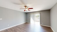 Located at 123 Patriot Dr in Bardstown, Kentucky, this single-floor residence offers a thoughtfully designed layout with 2 bedrooms, 2 bathrooms, a dedicated laundry area, and generous closet storage across four closets. The living room is a bright, open space highlighted by wood-look hardwood flooring, neutral gray walls, a ceiling fan with light fixture, and a sliding glass door fitted with vertical blinds that allows abundant natural light and outdoor views. The kitchen is well-equipped with gray cabinetry, granite-look countertops, stainless steel appliances including a range, microwave, and dishwasher, and a double-basin sink — all flowing seamlessly into the adjacent dining area. Both bathrooms feature matching gray vanity cabinetry with granite-style countertops, large mirrors with Hollywood-style lighting, and wood-look flooring. One bathroom includes a soaking tub and shower combination. The bedrooms continue the consistent aesthetic with soft gray walls, wood-look flooring, and ample natural light from windows with blinds. The primary bedroom is generously sized with a ceiling fan overhead. Throughout the residence, white panel doors, clean white trim, and a cohesive neutral color palette create a modern, move-in-ready atmosphere.
