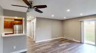 Located at 930 Cypress Pointe Dr in Crown Point, Indiana, this single-floor home offers a clean, modern aesthetic throughout. The open living area is a standout feature, showcasing rich, multi-toned vinyl plank flooring that runs seamlessly through the entire space. Recessed lighting and ceiling fans with integrated light fixtures provide ample illumination, while large sliding glass doors in the main living area flood the room with natural light and offer direct views of the surrounding greenery outside. Baseboard heating ensures year-round comfort throughout the home.

The kitchen is well-appointed with warm, medium-toned wood cabinetry, light countertops, and a full suite of stainless steel appliances, including a refrigerator, range, built-in microwave, and dishwasher. A barn-style sliding door adds a thoughtful design accent near the kitchen area.

The bedroom provides a quiet retreat with a ceiling fan, a bright window overlooking lush outdoor foliage, and consistent flooring that ties the space together. The bathroom is neatly finished with a white vanity, a shower-tub combination, and matching neutral wall tones. Additional hallway doors provide access to closets or utility areas. Overall, the home presents a cohesive, updated interior with a practical, comfortable layout.