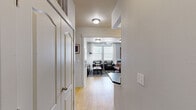 Located at 100 Hawk Ridge Dr in Iowa City, Iowa, this single-floor unit offers four bedrooms and four bathrooms across a compact yet efficiently organized layout. The living room serves as the heart of the space, featuring light hardwood-style flooring, large windows with blinds and draping white curtains, a ceiling fan, and abundant natural light. Built-in shelving and cabinetry line one wall, providing ample storage alongside stylish décor potential.

The galley-style kitchen is equipped with stainless steel appliances, dark countertops, warm wood cabinetry, and a double basin sink — offering a functional and streamlined cooking space. Three hallways connect the various rooms, ensuring smooth flow throughout.

Each bedroom is thoughtfully designed with ceiling fans, windows for natural light, and built-in desk and shelving units ideal for study or work. Select bedrooms feature walk-in closets and distinctive industrial-style pendant lighting paired with tiled accent headboard walls, adding a unique design character. Soft carpeting throughout the bedrooms enhances comfort.

The four bathrooms are clean and efficiently laid out, each featuring a tub-shower combination, wood-toned tall storage cabinetry, and light hardwood-style flooring. Three additional closets throughout the unit provide generous storage for all occupants.