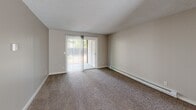 Located in Beaverton, Oregon, this one-bedroom, one-bathroom unit offers a practical and well-organized layout across a single floor. The living room is generously sized, featuring plush carpeting, a textured ceiling, a ceiling fan, baseboard heating, and a sliding glass door that opens to an outdoor patio area, filling the space with natural light. The kitchen and dining area flow together seamlessly, showcasing warm honey-toned wood cabinetry, dark countertops, hardwood-style flooring, a white electric range, and ample upper and lower cabinet storage. A window above the sink allows for additional natural light. The bedroom is a comfortable size, carpeted, and includes a window with a view of the surrounding greenery, baseboard heating, and access to two closets for generous storage. The full bathroom features a wood vanity with a dark countertop, a full tub-shower combination, and hardwood-style flooring. A dedicated laundry area adds everyday convenience. Neutral wall tones and textured ceilings carry throughout, providing a clean, cohesive aesthetic. This well-appointed unit offers a functional and comfortable living experience in a convenient Beaverton location.