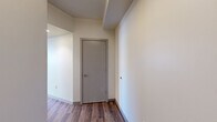 Located at 2645 Railroad St in Pittsburgh's Strip District, this modern 2-bedroom, 2-bathroom residence offers a well-designed single-floor layout with contemporary finishes throughout. The open-concept kitchen and living area serves as the heart of the home, featuring dark cabinetry, granite countertops, stainless steel appliances, and a freestanding island with a butcher block top—ideal for both cooking and casual dining. Rich hardwood-style flooring flows seamlessly throughout the entire space, enhancing its cohesive, modern aesthetic. The living area receives abundant natural light through large windows and sliding glass doors that lead directly to a private balcony with urban views. The spacious primary bedroom includes a large window bank overlooking the surrounding cityscape, while the second bedroom is equally well-lit with dedicated closet access. Both bathrooms continue the contemporary design language with dark vanity cabinetry and granite countertops. Additional highlights include five closets providing generous storage, a dedicated laundry area, and a connecting hallway that ensures a functional flow between rooms. This well-appointed residence combines practical urban living with polished, modern design in a prime Pittsburgh location.
