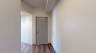 Located at 2645 Railroad St in Pittsburgh's Strip District, this modern 2-bedroom, 2-bathroom residence offers a well-designed single-floor layout with contemporary finishes throughout. The open-concept kitchen and living area serves as the heart of the home, featuring dark cabinetry, granite countertops, stainless steel appliances, and a freestanding island with a butcher block top—ideal for both cooking and casual dining. Rich hardwood-style flooring flows seamlessly throughout the entire space, enhancing its cohesive, modern aesthetic. The living area receives abundant natural light through large windows and sliding glass doors that lead directly to a private balcony with urban views. The spacious primary bedroom includes a large window bank overlooking the surrounding cityscape, while the second bedroom is equally well-lit with dedicated closet access. Both bathrooms continue the contemporary design language with dark vanity cabinetry and granite countertops. Additional highlights include five closets providing generous storage, a dedicated laundry area, and a connecting hallway that ensures a functional flow between rooms. This well-appointed residence combines practical urban living with polished, modern design in a prime Pittsburgh location.