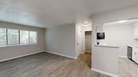 Located on Steam Mill Road in Columbus, Georgia, this 2-bedroom, 2-bathroom single-story home offers a clean, modern aesthetic throughout. Wood-look luxury vinyl flooring runs through the main living areas, kitchen, and hallway, creating a cohesive and easy-to-maintain finish. The living room is open and bright, flowing naturally into the dining area and kitchen. The kitchen is well-equipped with white shaker-style cabinetry, marble-look countertops, a white subway tile backsplash, a black refrigerator, dishwasher, and stove, all set against light wood-look floors. A pass-through counter connects the kitchen to the dining area, enhancing the open feel of the shared living space. Both bedrooms are carpeted and include ceiling fans with natural light from windows. The primary bedroom features a generously sized walk-in closet. The bathrooms are finished with white vanities, marble-look countertops, and tub-shower combinations. A dedicated laundry room with washer and dryer hookups adds everyday convenience. Four total closets throughout the home provide excellent storage. The neutral gray and beige color palette throughout gives the space a clean, move-in-ready appearance.