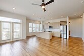 Located at 2825 W 11th St in Houston's sought-after Heights neighborhood, this modern single-floor, 2-bedroom, 1-bathroom home offers a thoughtfully designed open-concept layout. Warm hardwood flooring flows seamlessly throughout, complementing the bright, neutral palette.

The combined living, dining, and kitchen area serves as the heart of the home. The kitchen is outfitted with light wood cabinetry, a white quartz-topped island with a matte black sink, stainless steel appliances, a built-in wine rack, and pendant lighting — all bathed in natural light from large windows. A ceiling fan with integrated lighting anchors the living area, which opens to a private balcony.

The primary bedroom is generously sized and features direct balcony access through glass doors, flooding the room with natural light and outdoor views. The second bedroom includes a ceiling fan and a bank of windows overlooking the neighborhood. Both bedrooms are served by well-organized closets, including a walk-in with built-in shelving.

The bathroom is elegantly finished with large-format marble-look tile on both the floors and tub surround, paired with matte black fixtures and a light wood vanity. Additional spaces include a dedicated laundry area and a pantry, rounding out this efficiently designed and stylish home.