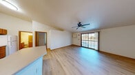 Located at 1415 Silverstone Trl in De Pere, Wisconsin, this well-laid-out two-bedroom, two-bathroom home offers comfortable single-floor living. The bright living room serves as the heart of the home, featuring light wood laminate flooring, a ceiling fan, and a sliding glass door that opens to a balcony with outdoor views, filling the space with natural light. Adjacent to the living area, the kitchen is equipped with warm oak cabinetry, generous counter space, a double basin sink, dishwasher, and electric range, complemented by easy-to-maintain wood flooring. A hallway connects the main living areas to the private quarters, where both bedrooms are finished with plush neutral carpet. The spacious primary bedroom includes a sliding closet door and additional entry door, offering practical storage. The second bedroom benefits from two windows that invite ample natural light. The two bathrooms are well-appointed: one features a full tub and shower combination, while the other includes a walk-in glass shower, an extended vanity with dual sinks and oak cabinetry, and a large mirror. Consistent warm wood trim and white walls create a clean, cohesive aesthetic throughout the entire home.