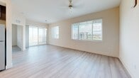 Located in Palmetto, FL, this well-appointed single-floor home offers three bedrooms and one bathroom with a clean, modern aesthetic throughout. Light wood-style flooring flows seamlessly across every room, complementing the warm neutral walls and crisp white trim that define the interior.

The open-concept living area is bright and airy, with multiple windows dressed in horizontal blinds that invite natural light, a ceiling fan overhead, and sliding glass doors leading to a private balcony with outdoor views of the surrounding area.

The kitchen is a standout, featuring rich dark cabinetry, a white subway tile backsplash, light quartz countertops, a central island, and a full suite of stainless steel appliances including a refrigerator, range, microwave, and dishwasher. Pendant lighting and recessed fixtures add warmth and functionality.

The spacious primary bedroom offers ample room for a full furniture arrangement, while all bedrooms include closets with built-in shelving. Hallways connect the bedrooms with ease, and the shared bathroom is finished with a dark-toned vanity, white countertop, a large framed mirror, and light flooring that ties the space together cohesively.