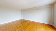 Located at 1629 Columbia Rd NW in Washington, DC's dynamic Adams Morgan neighborhood, this one-bedroom, one-bathroom residence offers a well-organized, efficiently laid-out living space across a single floor. Warm-toned hardwood floors flow throughout the unit, lending a cohesive and polished look to every room.

The living room is a bright, open area anchored by large windows and a glass balcony door that opens to a private outdoor balcony. From this elevated vantage point, sweeping panoramic views of Washington, DC's tree-lined rooftops and cityscape stretch into the distance — a standout feature of the space.

The bedroom is generously proportioned, offering a wide bay of windows that frame additional city views and fill the room with natural light. A double-door closet provides ample storage, keeping the space functional and organized.

The kitchen, visible from the floor plan, features a peninsula-style layout that separates it from the living area. The bathroom is finished with light-toned tile flooring, white subway-style wall tile wainscoting, a natural-light window, and a wall-mounted grab bar, adding both practicality and a clean, neutral aesthetic.

A connecting hallway ties all rooms together, completing this well-appointed urban residence.
